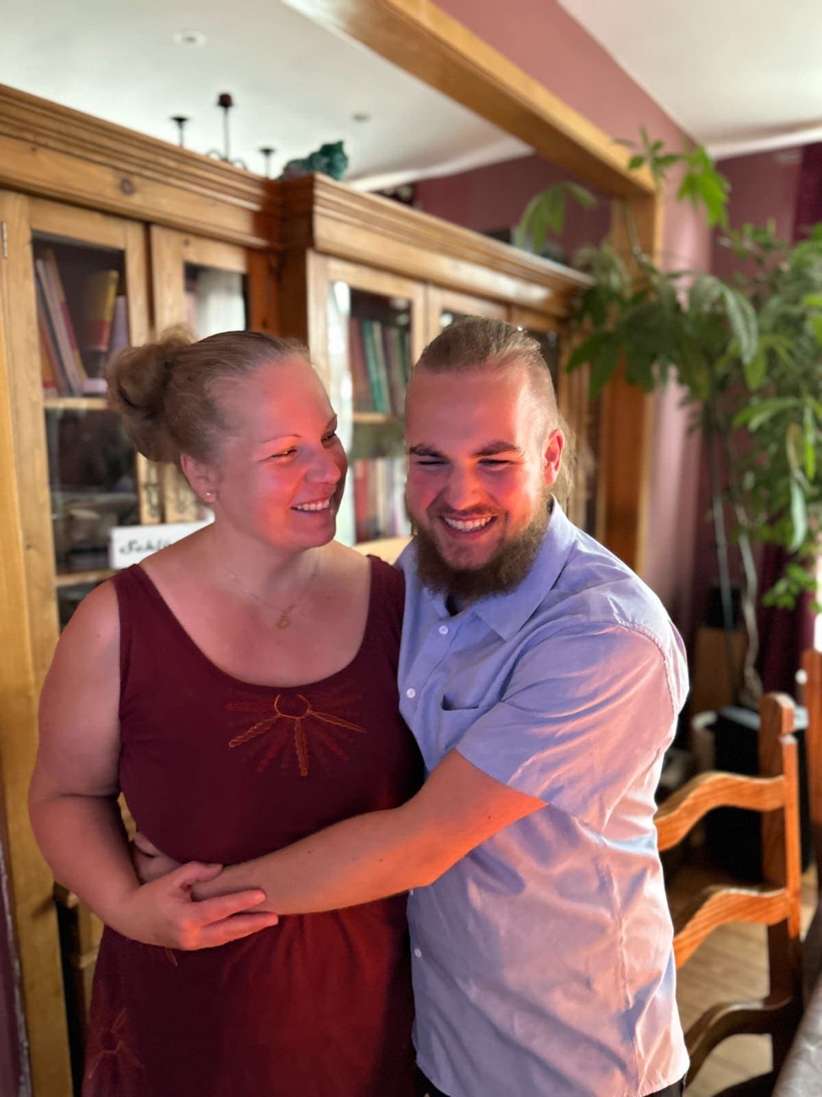 Mika und Vinayaki-Anne Arm in Arm vor einem Bücherschrank