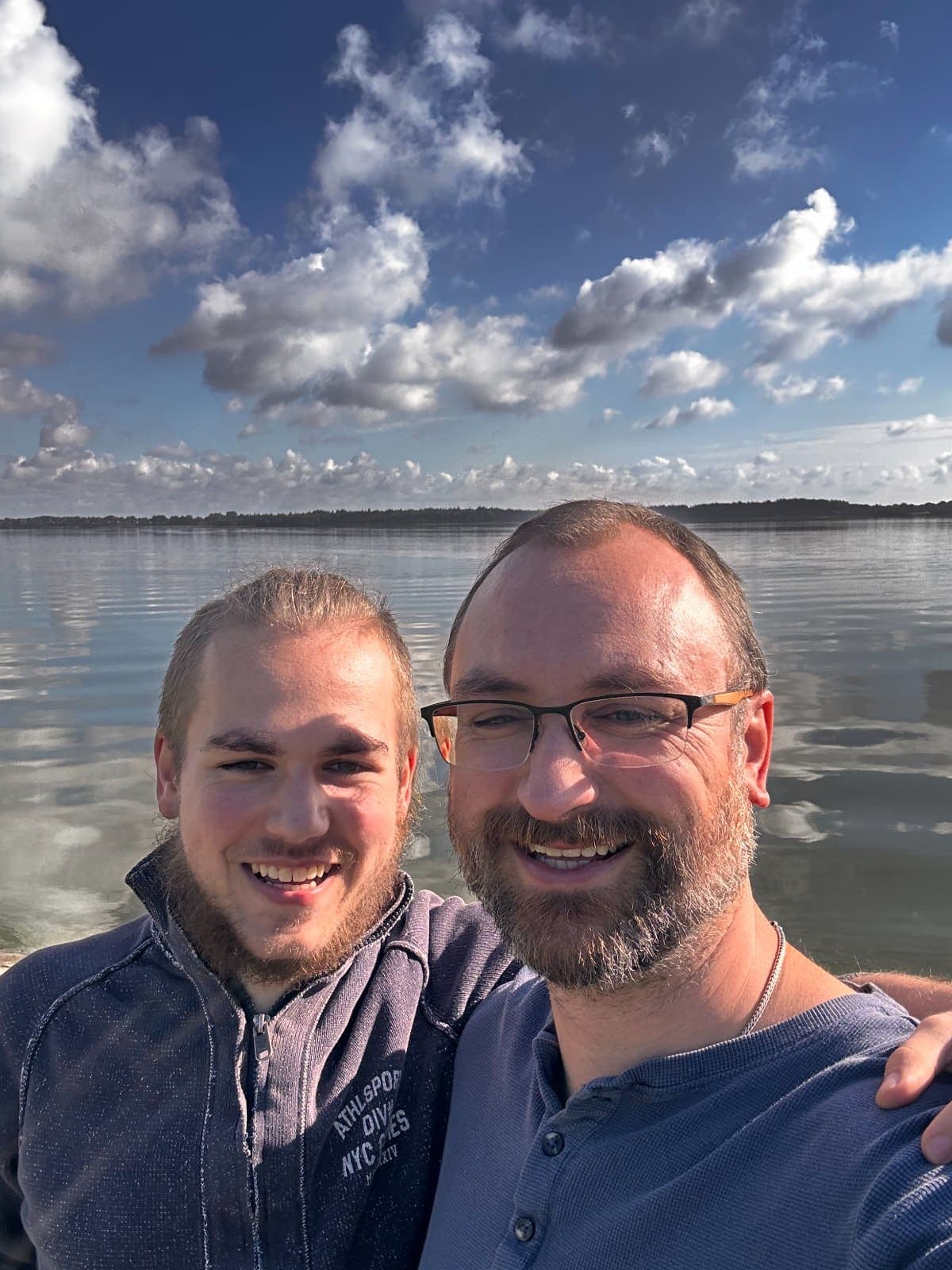 Robert und Mika am Wasser unter einem weiten Wolkenhimmel